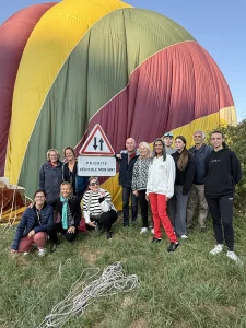 Passagers posant devant une montgolfière après un vol en montgolfière Beaujolais près de Lyon